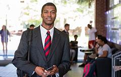 Male student in suit inside of MCOB Building lobby,